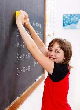 Elementary school student erasing chalkboard Stock Photos