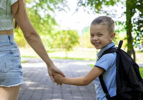 An elementary school student going to study. A first grader holds his mother' Stock Photos