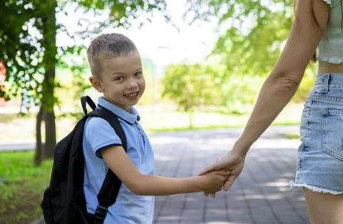 An elementary school student going to study. A first grader holds his mother' Stock Photos