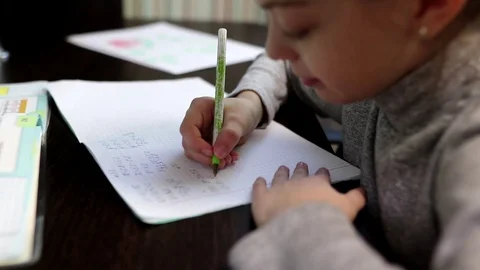 Elementary school student sitting at home at the table doing homework in math Video stock 102171112