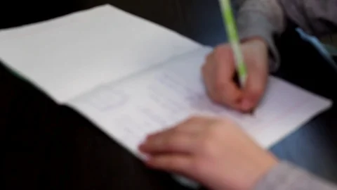 Elementary school student sitting at home at the table doing homework in math Video stock 102171200