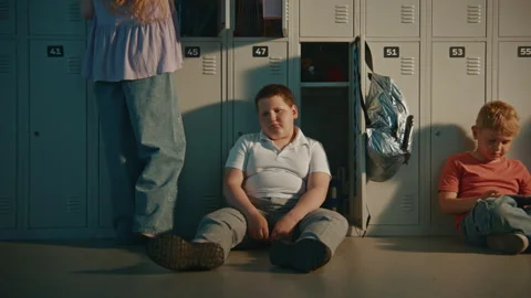 Elementary School Student Sitting Silently on Metal Lockers in School Break Stock Footage 342040376