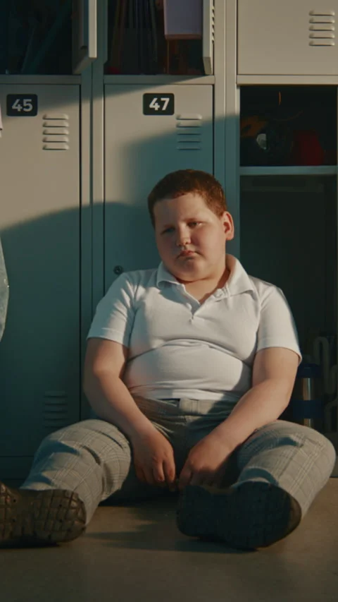 Elementary School Student Sitting Silently on Metal Lockers in School Break Stock Footage 342046661