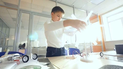 Elementary school student studies alternative energy with wind turbine and solar Video stock 75252069