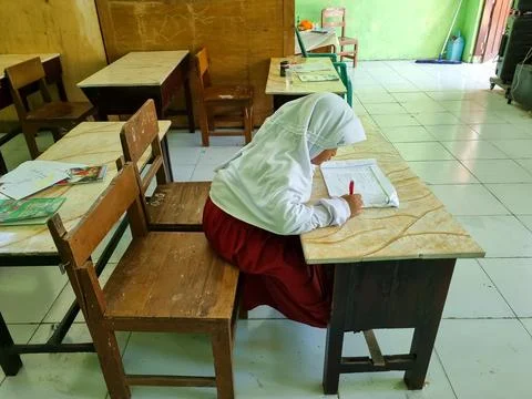 An elementary school student is writing on a table Stock Photos
