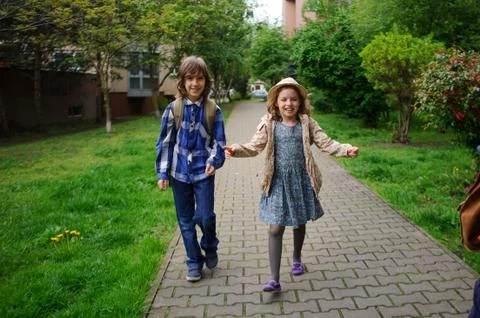 Elementary school students hurry to school. Stock Photos