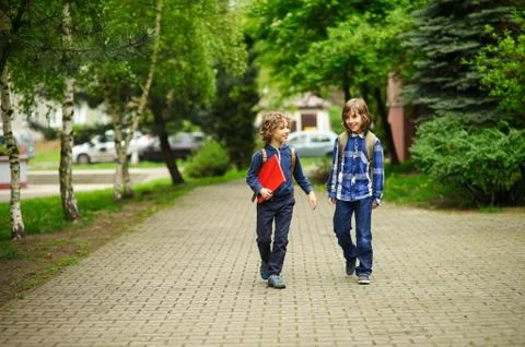 Elementary school students hurry to school. Stock Photos