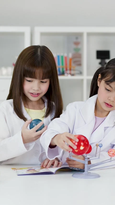 Elementary School Students in Lab Coats Studying Solar System Model Stock Footage 344943920