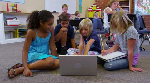 Elementary school students look at laptop computer together Stock Footage 32728755