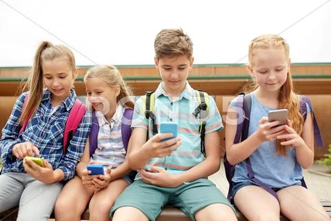 Elementary school students with smartphones Stock Photos