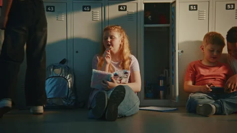 Elementary School Students Spending Free Time in Hallway, Sitting on Floor near Stock Footage 342025698