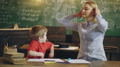 Elementary school. Teacher and pupil in classroom with backbord background, back Stock Footage 144040225