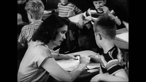 Elementary School Teacher In Classroom Helps Students With Homework Stock Footage 157788797
