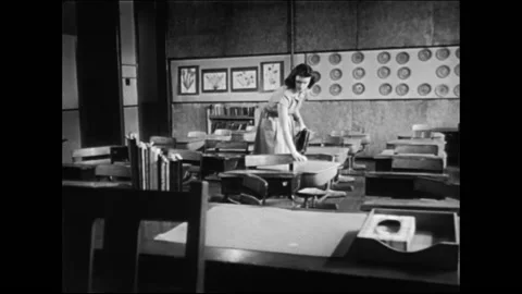 Elementary School Teacher In Empty Classroom Controlling Students Desks Stock Footage 157788572