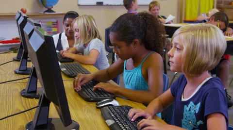 Elementary school teacher helps students with computers Stockbeeldmateriaal 62281992