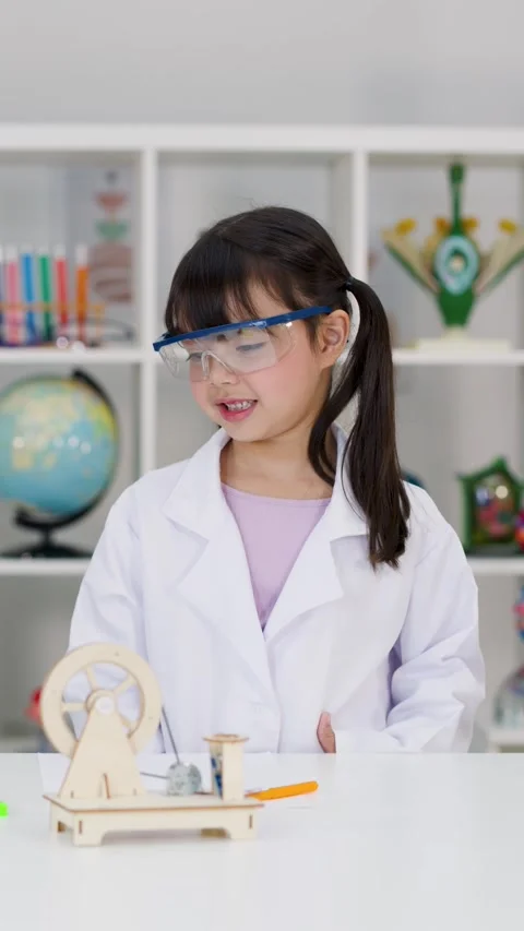 Elementary Student in Lab Coat Conducting Science Experiment in Classroom Stock Footage 341375925