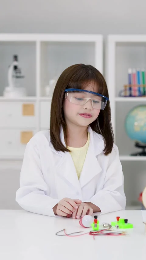 Elementary Student in Lab Coat Conducting Electronics Science Experiment Stock Footage 341392621