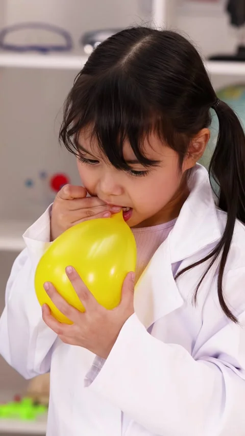 Elementary Student in Lab Coat Deflating Yellow Balloon Stock Footage 344105067