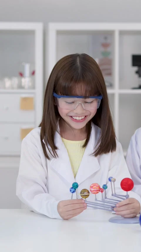 Elementary Student in Lab Coat Examining Solar System Model Stock Footage 341392955