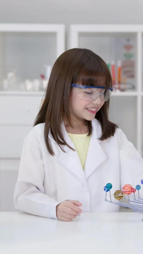 Elementary Student in Lab Coat Examining Solar System Model Stock Footage 346365435