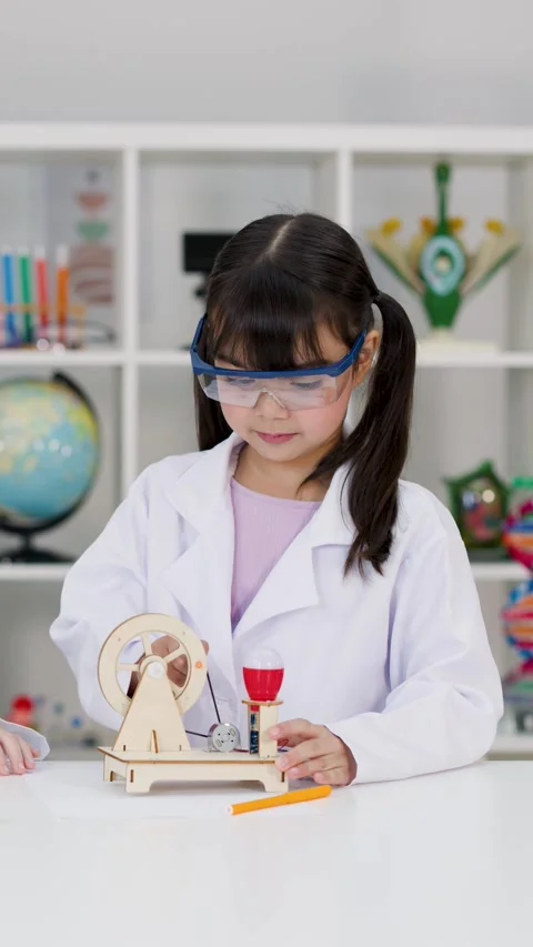 Elementary Student in Lab Coat Operating Wooden STEM Engineering Project Stock Footage 342785581