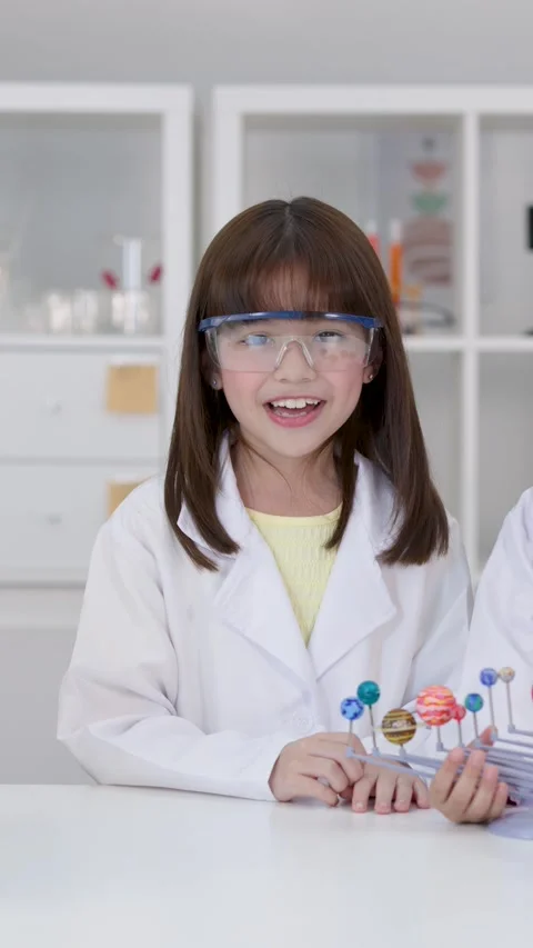 Elementary Student in Lab Coat Presenting Solar System Model Stock Footage 341393094