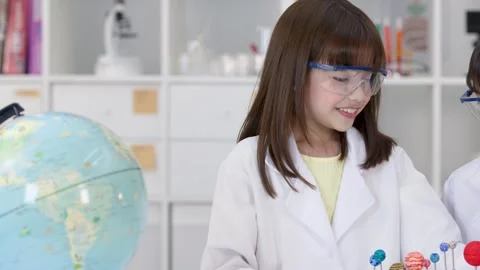 Elementary Student in Lab Coat Studying Solar System Model Stock Footage 346453150
