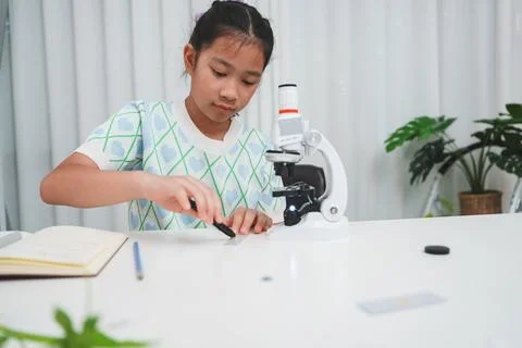 Elementary student preparing slide for microscope during hands on science Stock Photos