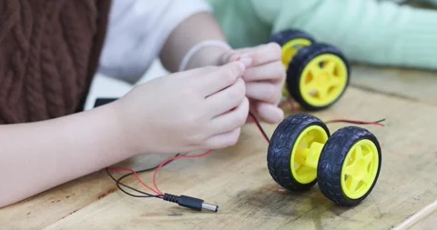 Elementary students assembling a robot car and connecting electronic wires .. Stock Footage 339606031