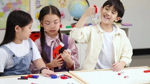 Elementary Students Exploring Magnetism in Science Classroom Experiment Stock Footage 325023774