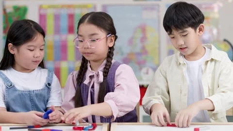 Elementary Students Exploring Magnets During Hands-On Science Activity Stock Footage 329608670