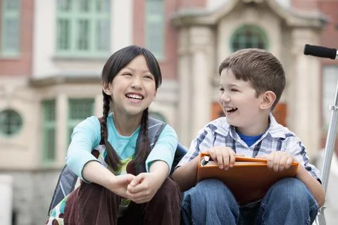 Elementary students in front of school building Stock Photos