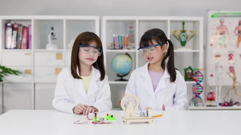Elementary Students in Lab Coats Conducting Electronics Experiment Stock Footage 340009489