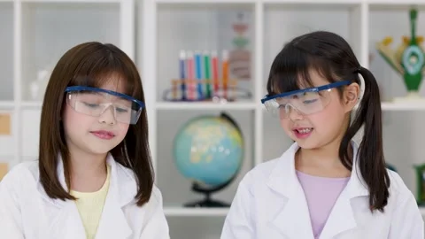 Elementary Students in Lab Coats Conducting Science Experiment in Classroom Stock Footage 341917222