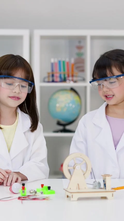 Elementary Students in Lab Coats Conducting Electronics Science Experiment Stock Footage 345101431