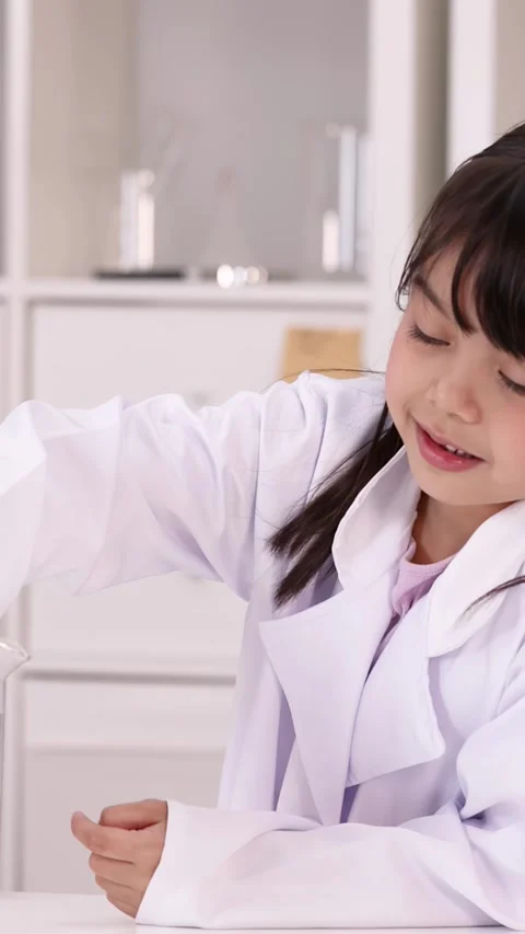 Elementary Students in Lab Coats Conducting Science Experiment with Beaker Stock Footage 345799503