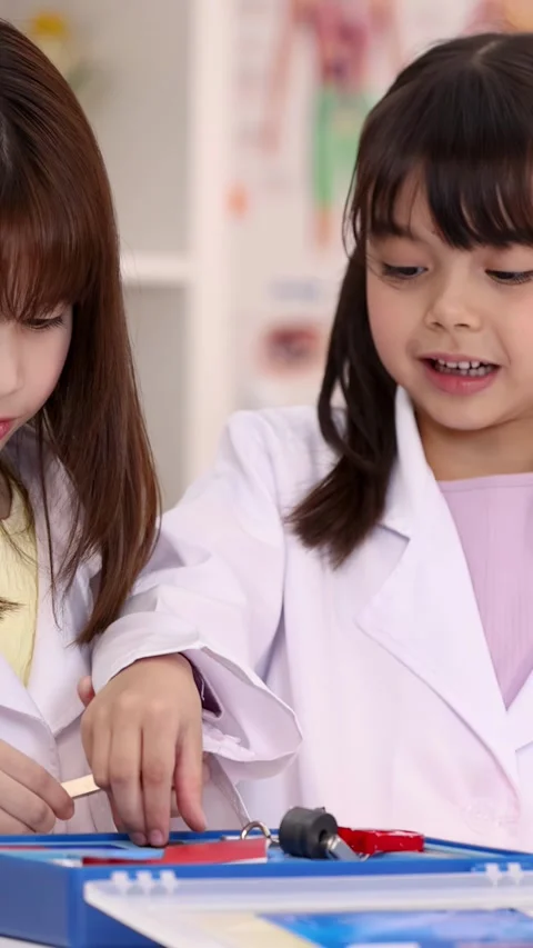 Elementary Students in Lab Coats Conducting Physics Magnet Experiment Stock Footage 346932913