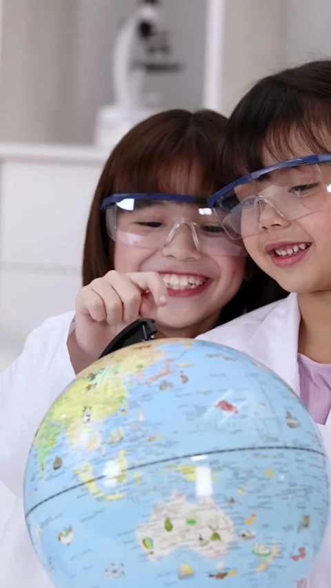 Elementary Students in Lab Coats Examining World Globe in Science Class Stock Footage 341667676