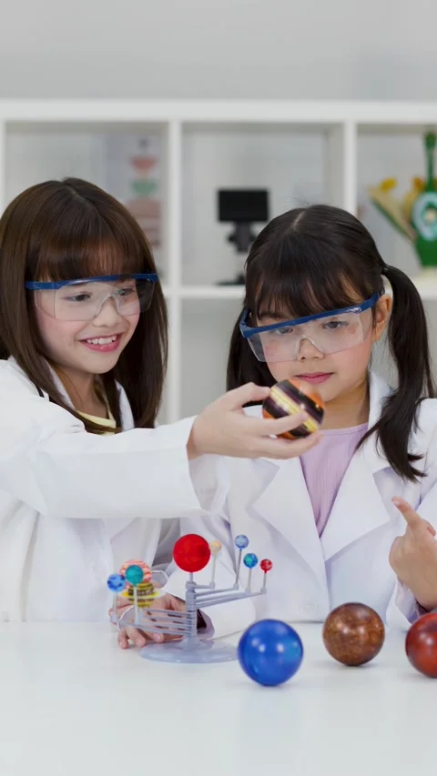 Elementary Students in Lab Coats Studying Solar System Model Stock Footage 340118074