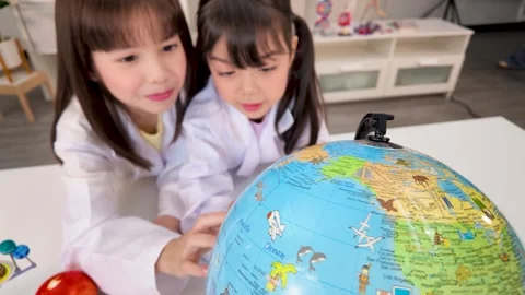 Elementary Students in Lab Coats Studying World Globe in Science Classroom Stock Footage 340183131