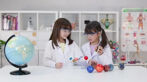 Elementary Students in Lab Coats Studying Solar System Model Stock Footage 340244289