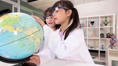 Elementary Students in Lab Coats Studying World Globe in Science Classroom Stock Footage 340244376