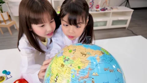 Elementary Students in Lab Coats Studying World Globe in Classroom Stock Footage 340244430