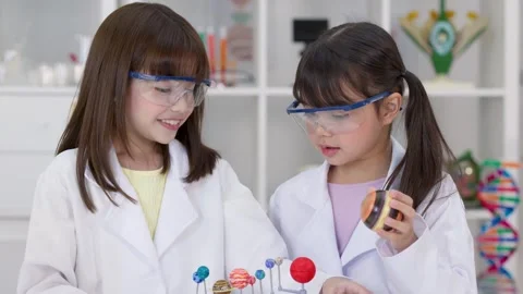 Elementary Students in Lab Coats Studying Solar System Model Stock Footage 340244439