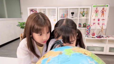 Elementary Students in Lab Coats Studying World Globe in Science Classroom Stock Footage 340775089