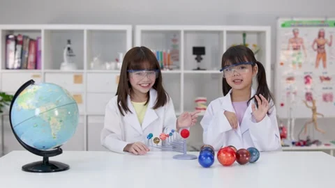 Elementary Students in Lab Coats Studying Solar System Model in Science Class Stock Footage 340775297