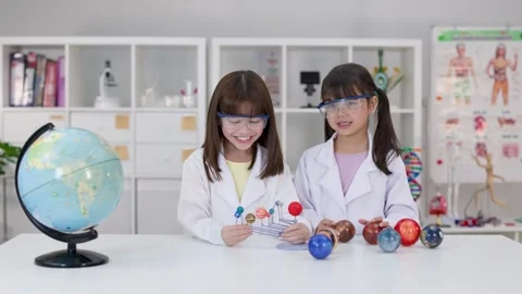Elementary Students in Lab Coats Studying Solar System Model Stock Footage 340775301