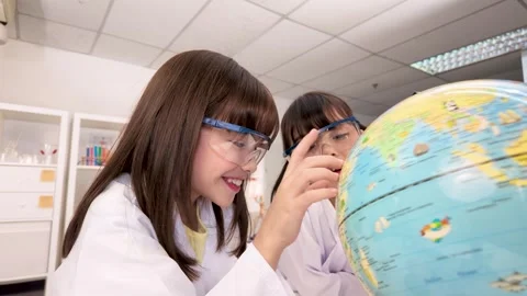 Elementary Students in Lab Coats Studying World Globe in Science Classroom Stock Footage 340775341