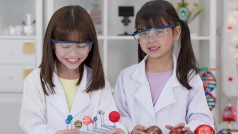 Elementary Students in Lab Coats Studying Solar System Model Stock Footage 341073999