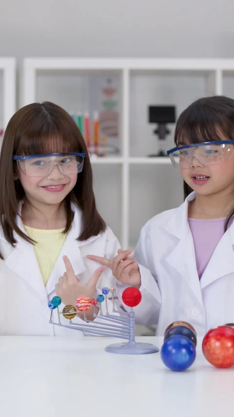 Elementary Students in Lab Coats Studying Solar System Model Stock Footage 341074030